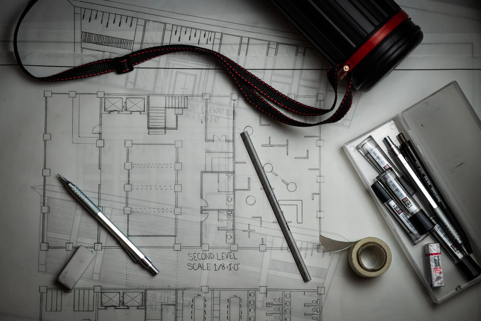 Documentos legales y un plano arquitectónico sobre un escritorio de madera