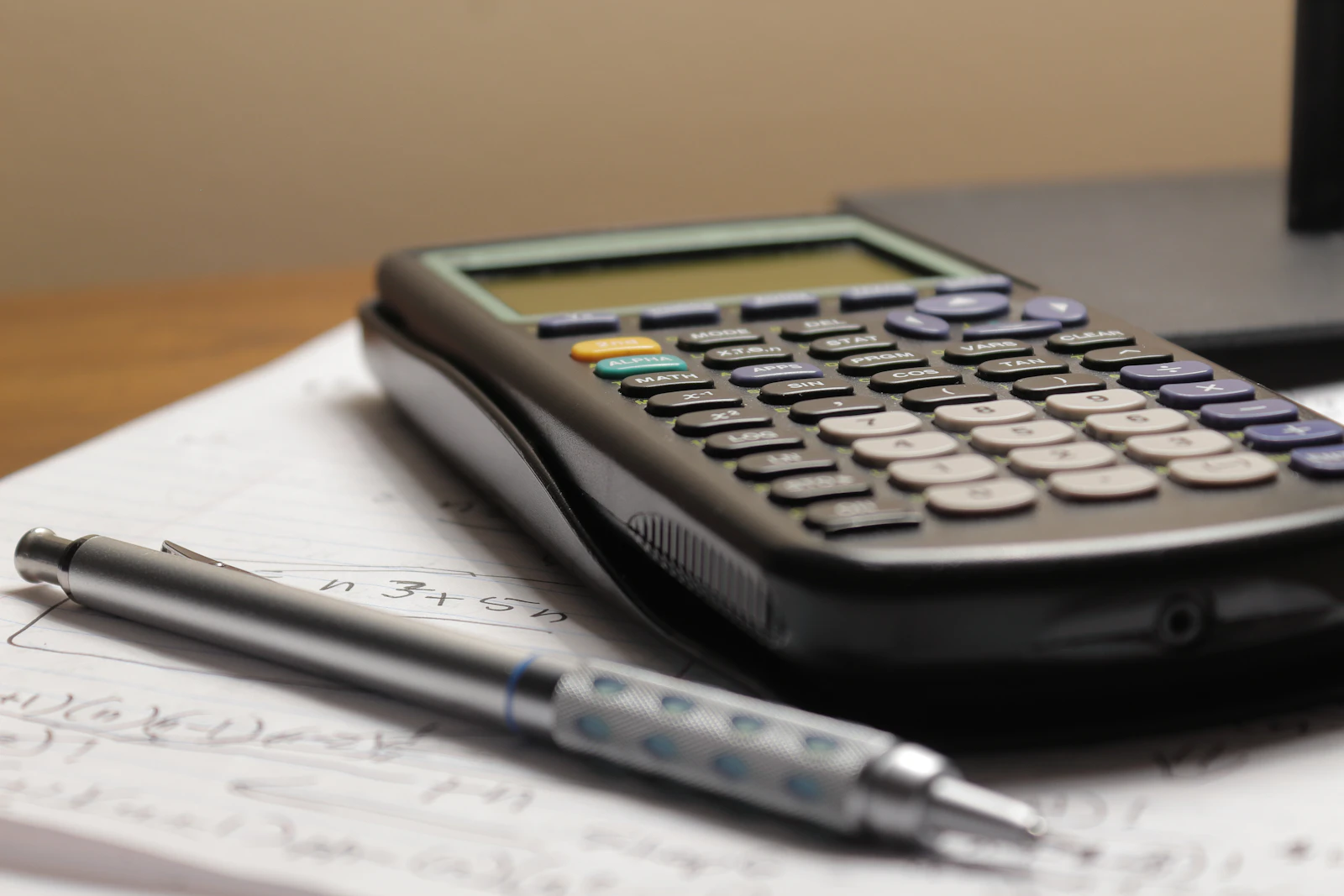Calculadora, monedas y un contrato de arrendamiento sobre un escritorio